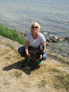 Andrea in der Hocke mit Hund am Rhein